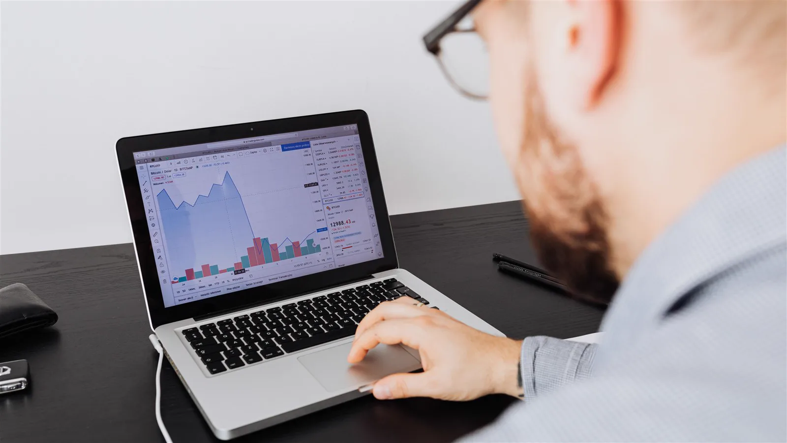 Man reviewing financial charts and data on a laptop screen
