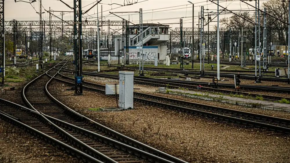 Railway track junction with multiple signal heads and overhead signalling infrastructure