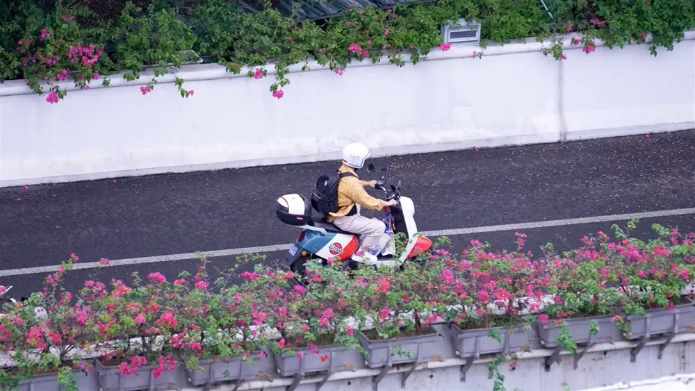 Rider on a scooter moving along a city road
